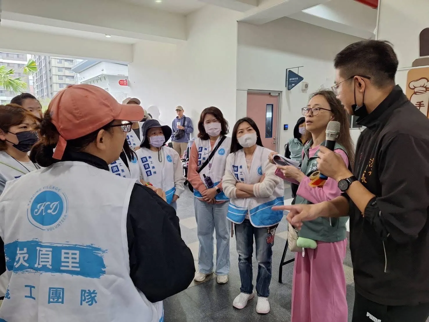 崁頂里里長吳庭岳與志工團隊說明活動現場注意事項，確保里內活動運行順利。（圖片來源：揪里嗨）