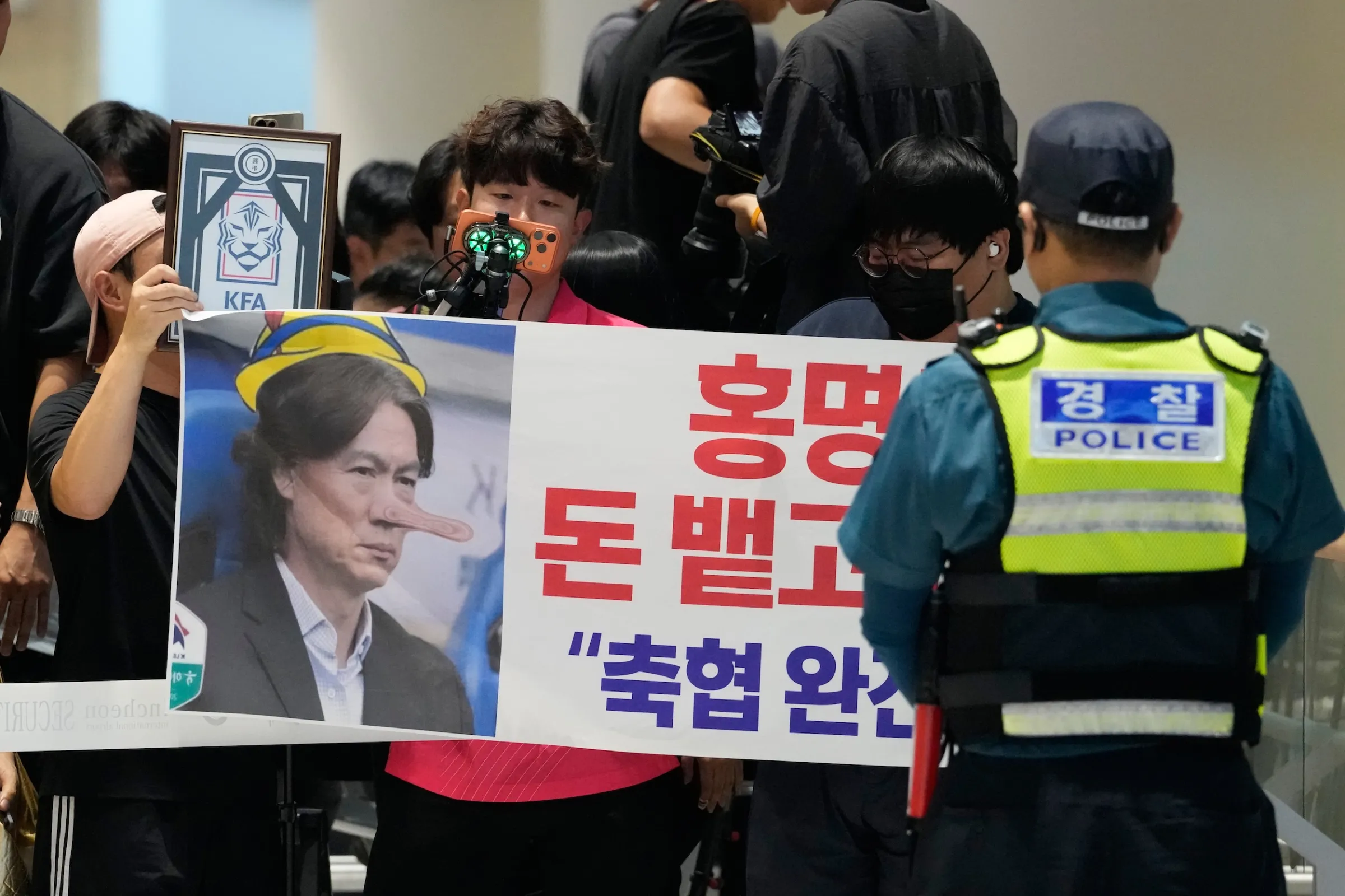 2026年6月30日，韓國仁川國際機場，韓國足球隊總教練洪明甫因球隊淘汰主動辭職，球迷在機場高舉抗議布條「洪明甫！把錢吐出來滾蛋！解散韓國足協！」（美聯社）