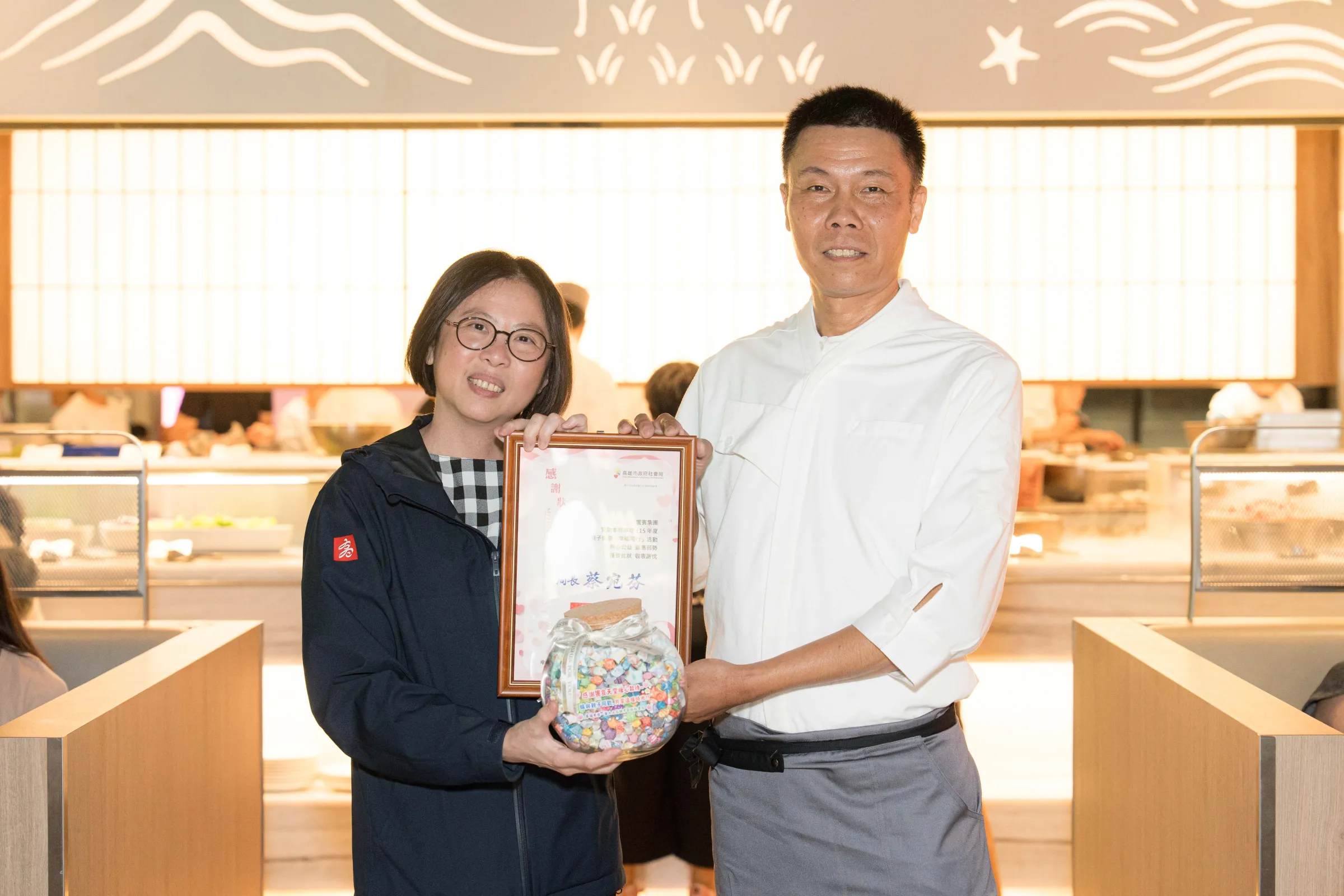 蔡宛芬（左）局長致贈饗賓集團感謝狀，由饗食天堂行政主廚洪進發代收。（圖/高市社會局提供）