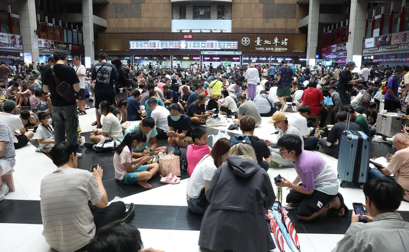 颱風天台北車站湧人潮抓寶可夢（1） 台北車站大廳11日湧入大量民眾，不少人席地而坐、操作手機參與寶可夢活動，現場人潮相當密集。中央社記者謝佳璋攝115年7月11日