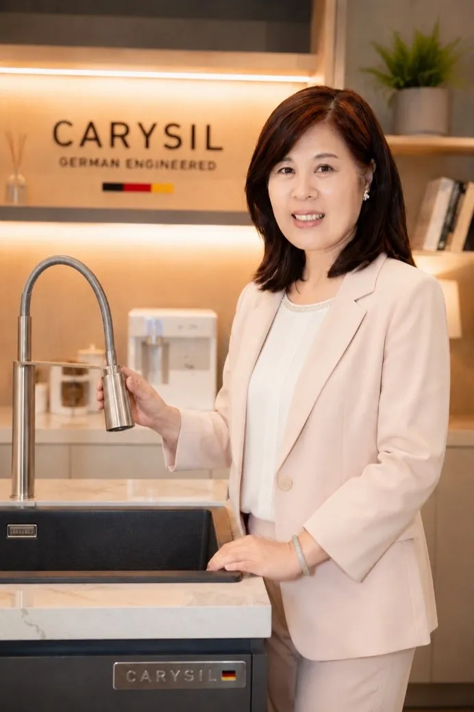 艾美廚衛董事長王麗娟展示德國Carysil柯瑞伸縮式水龍頭，強調廚房設備應兼顧美學、耐用性及使用便利，讓料理與清潔更加順手。（圖／艾美廚衛提供）