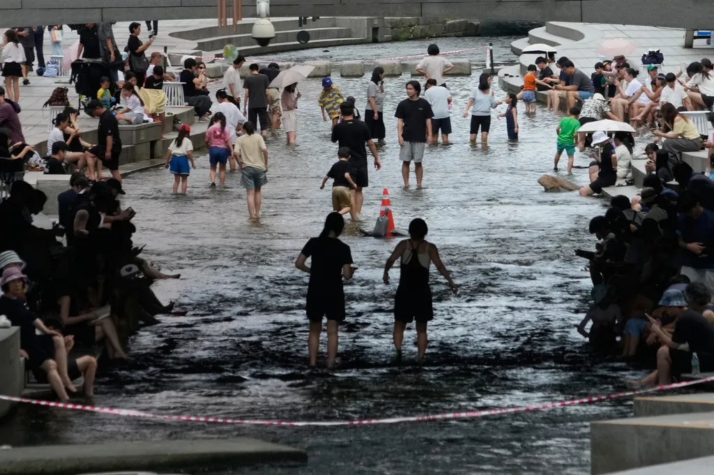南韓近日遭遇攝氏38度以上高溫熱浪襲擊，圖為民眾在首爾清溪川嬉戲。（美聯社）