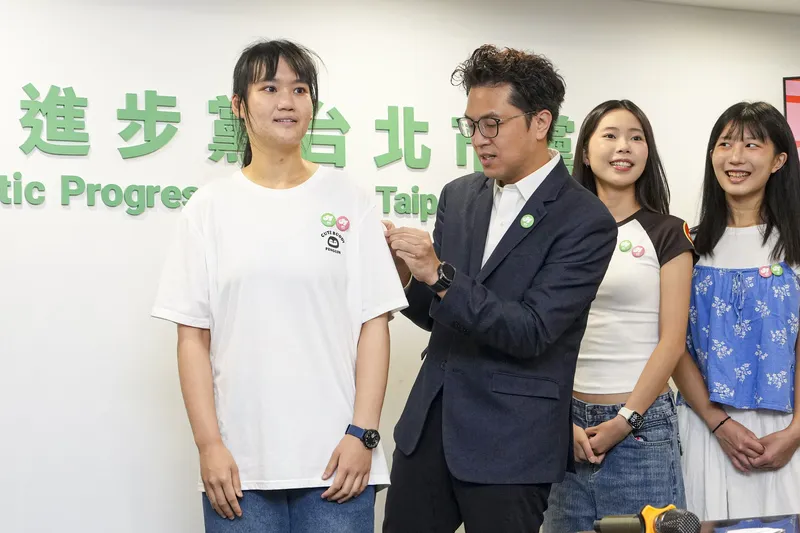 沈伯洋氏の主力チームには、社会運動に関わっていた頃の仲間や各方面から集まった若者がいる。写真は、若者チームのメンバーに「巡洋監兵」のステッカーを貼り、開票監視ボランティアへの参加を呼びかける沈氏（左から2人目）（中央社）