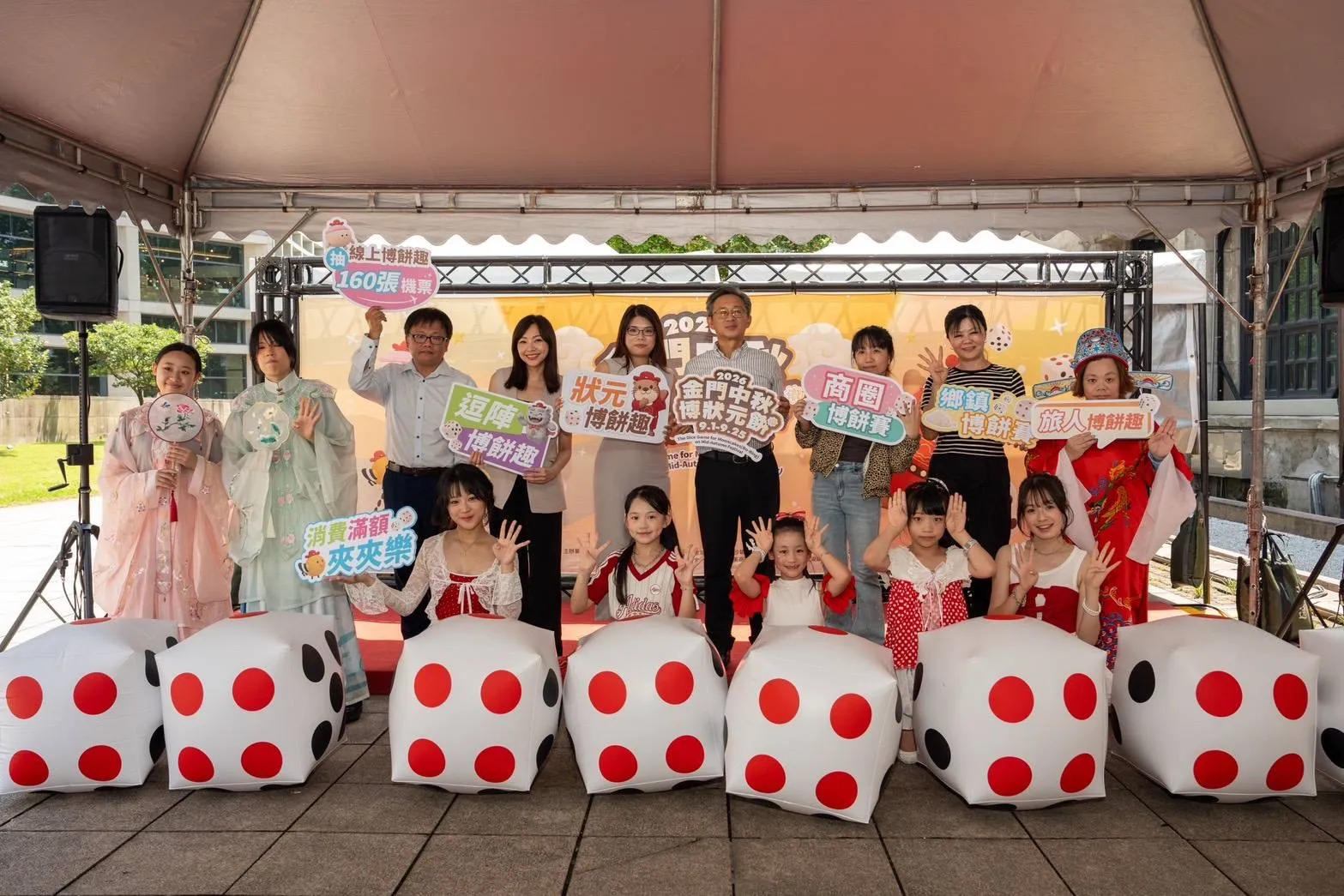 金門中秋博狀元餅宣傳記者會在臺北松菸登場，貴賓與表演團隊手持活動看板合影，邀請全臺旅客走進金門體驗百年民俗。（圖／金門縣政府提供）