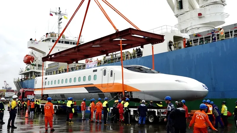 台灣高鐵N700ST全新車型抵台（3） 台灣高鐵首組N700ST列車15日抵台，率先亮相的車頭在雨中從船艙順利降置在碼頭邊的拖車上，宣告N700ST自即日起正式在台灣落地生根。中央社記者董俊志攝115年8月15日