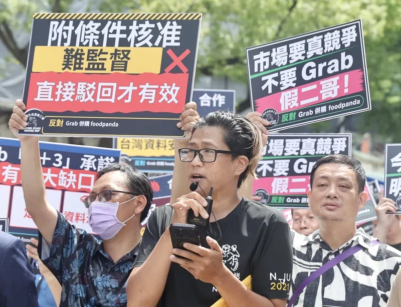 外送工會籲公平會否決Grab併購案（3） 全國外送產業工會等團體18日在公平交易委員會前舉行記者會，針對外送平台Grab併購foodpanda表達強烈反對，全國外送產業工會理事長陳昱安（中）表示，連白紙黑字的法律都有人敢違反，更何況是脆弱的企業口頭保證，一旦市場競爭因併購而消滅，所造成的全面性傷害將永遠無法挽回。中央社記者張皓安攝115年8月18日