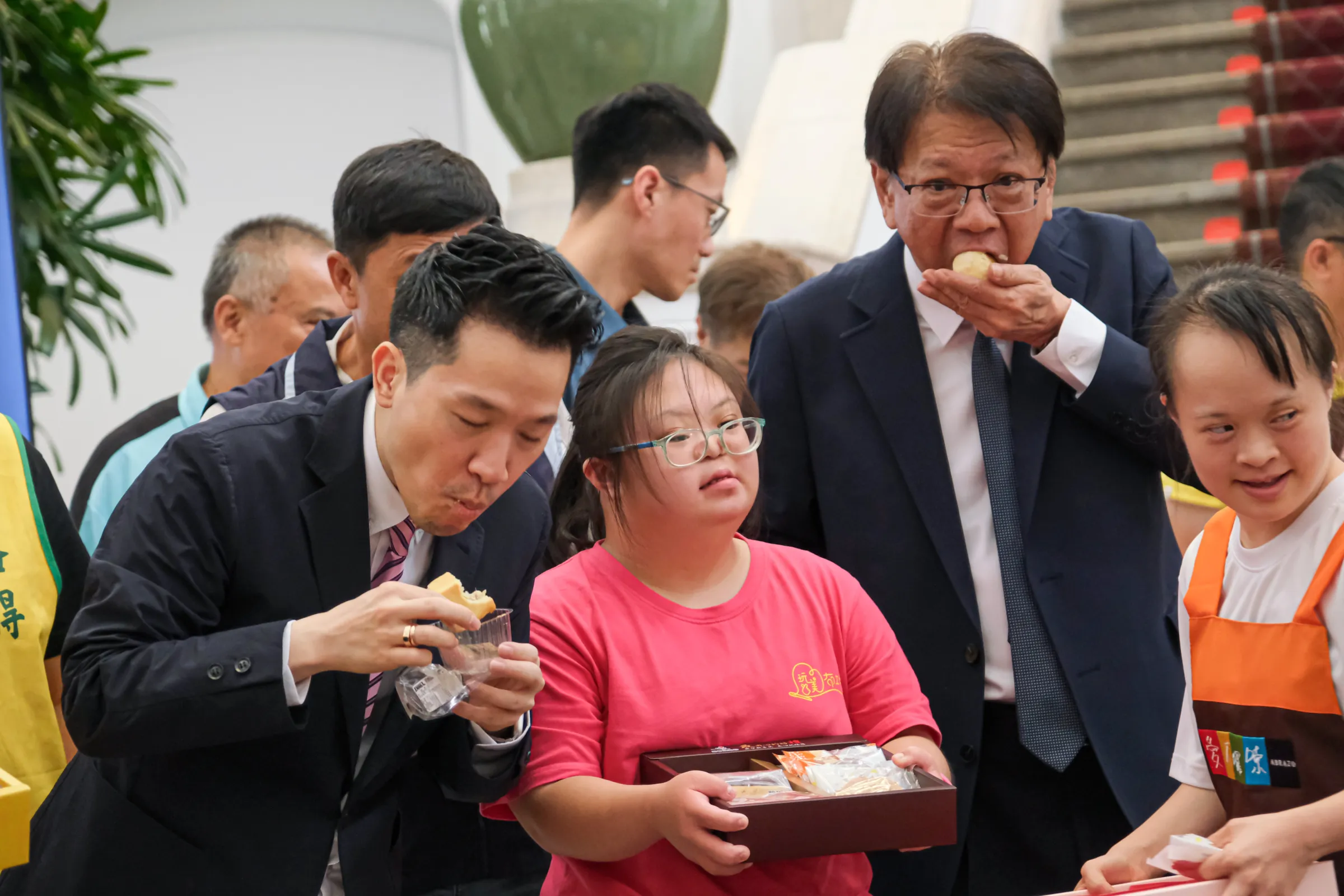 20260820-「好事成圓，全民挺公益，讓中秋的愛不刪減」記者會20日於總統府舉行，圖為總統府副秘書長何志偉（左）、總統府秘書長潘孟安（右）一起品嚐餅乾。（劉偉宏攝）