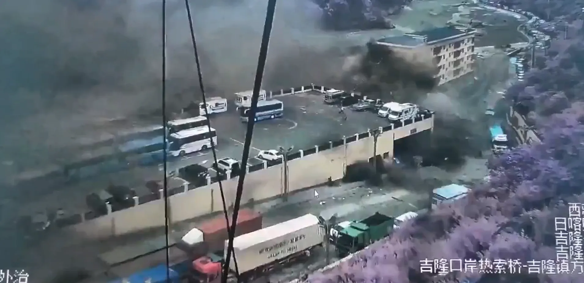 中國西藏邊境地區監視鏡頭拍下的洪災瞬間畫面，龐大洪流混雜泥漿吞沒城鎮街道。（翻攝自社群影片）