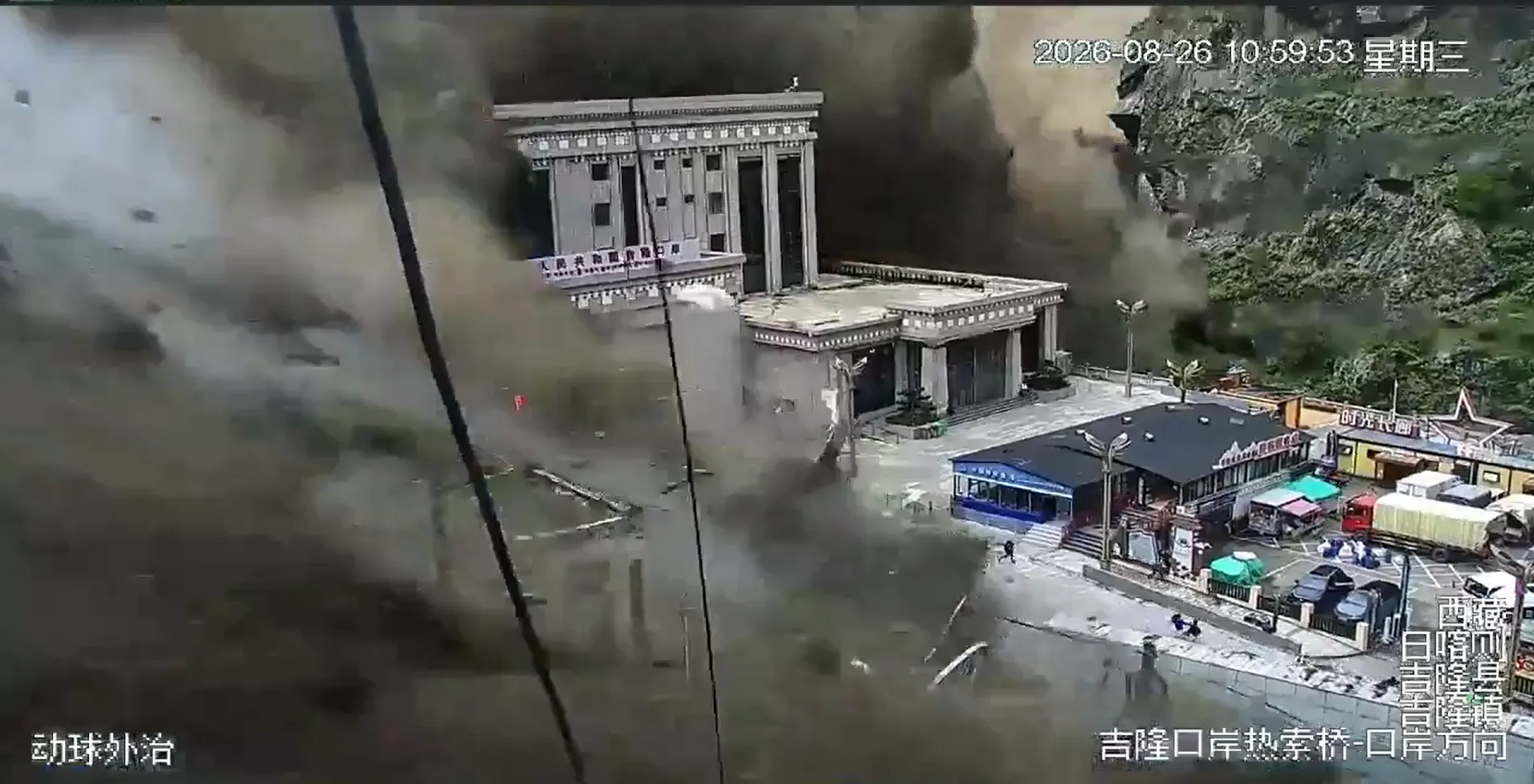 中國西藏邊境地區監視鏡頭拍下的洪災瞬間畫面，龐大洪流混雜泥漿吞沒城鎮街道。（翻攝自社群影片）
