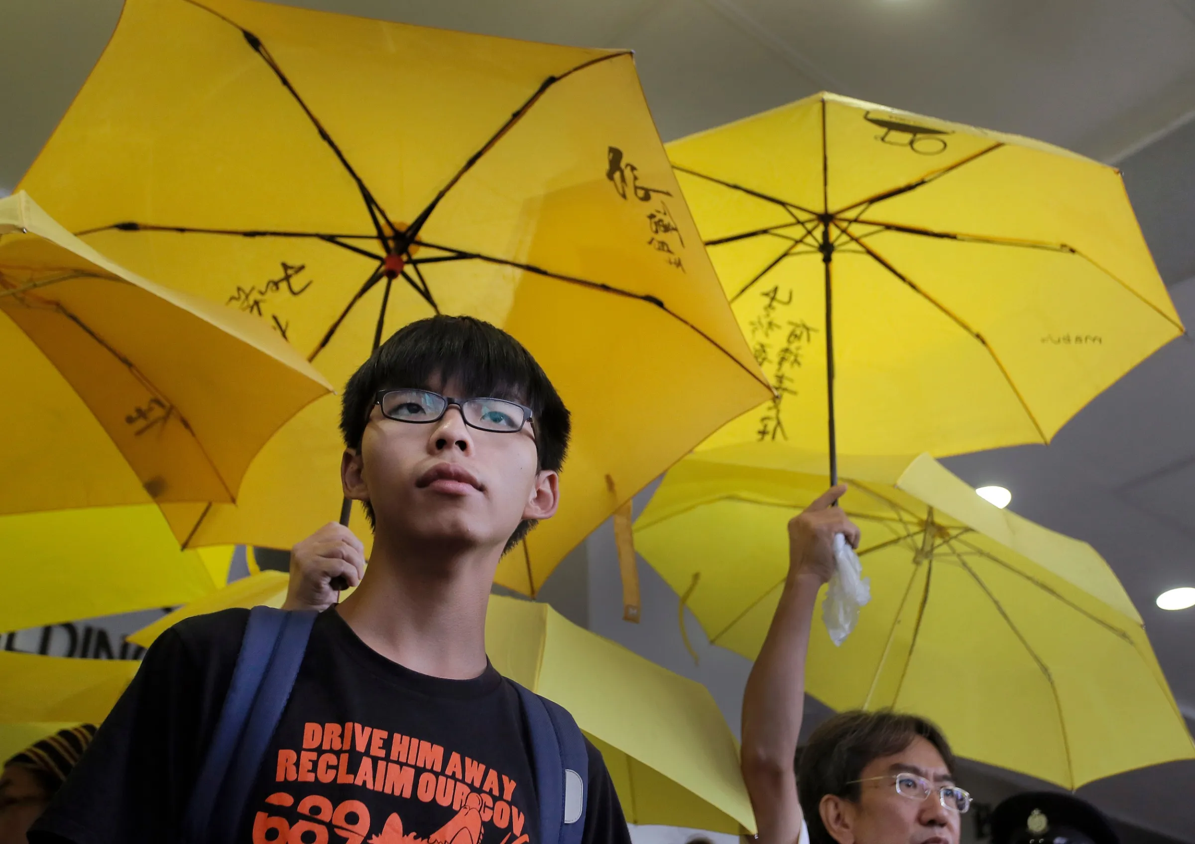 2015年9月2日，香港學運領袖黃之鋒（左）在法院外抗議。（美聯社）