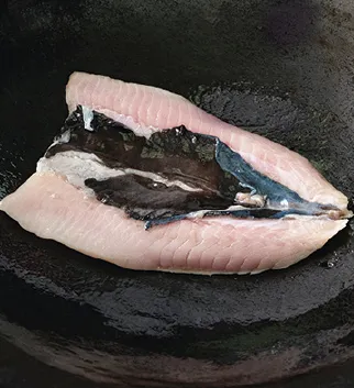虱目魚以魚皮面朝下入鍋。（圖／台灣廣廈有聲圖書有限公司提供）