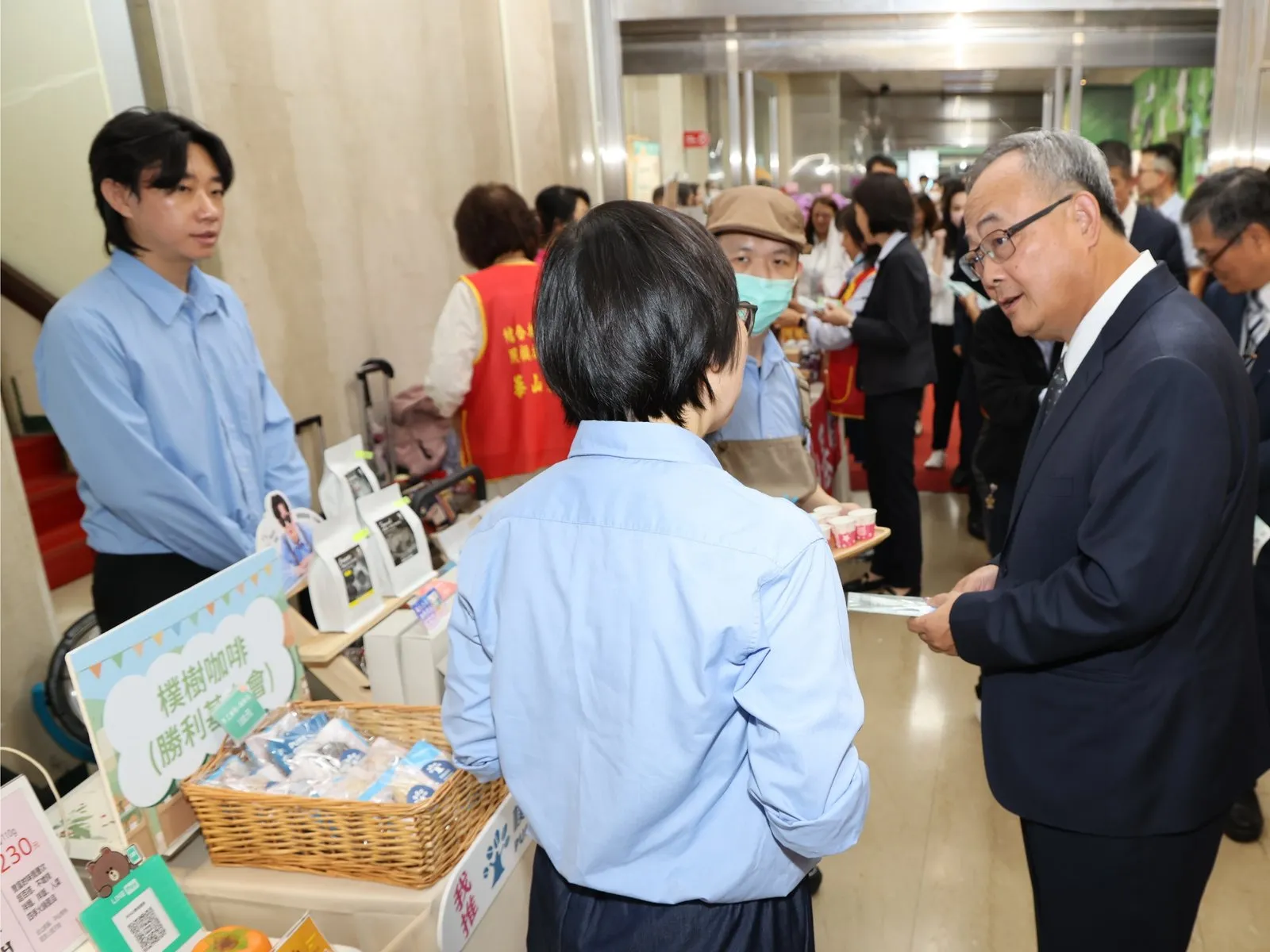 土地銀行總經理張志堅(右一)巡視公益市集攤位，選購特色商品，以行動支持社會公益及在地農業。