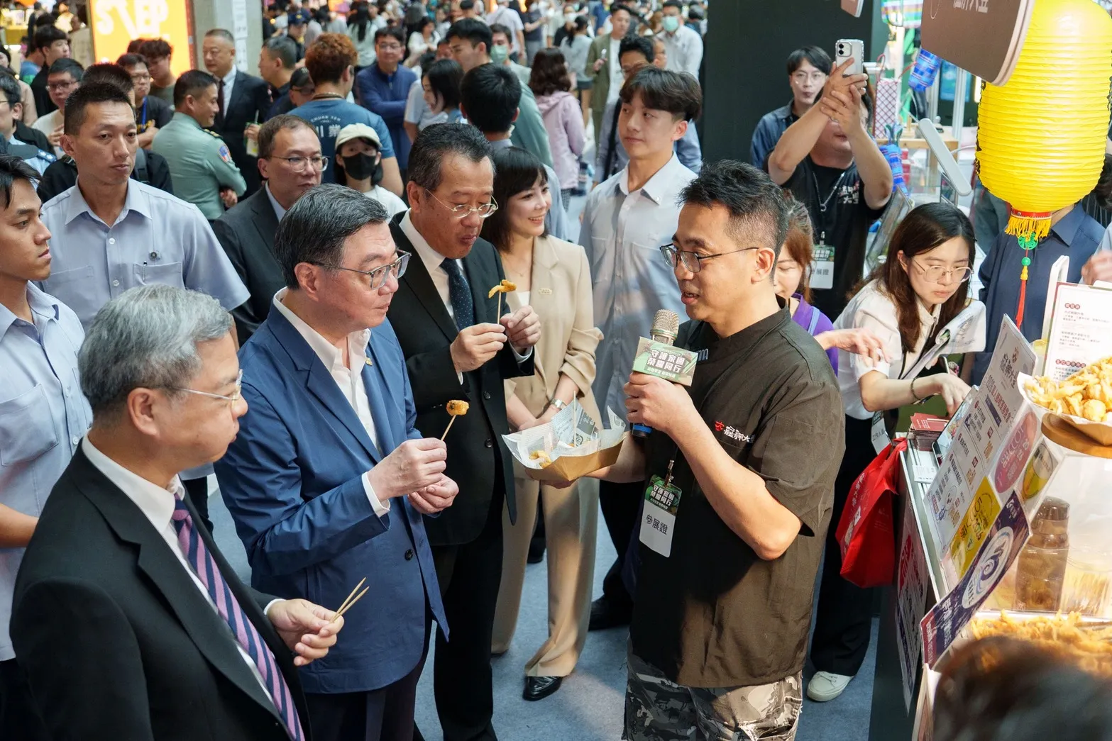 行政院卓榮泰院長走訪展售攤位，與業者親切互動，品嚐特色美食。（圖／經濟部商業發展署提供）