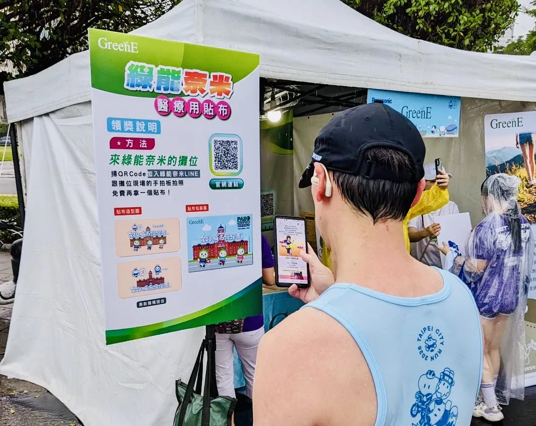 跑者掃描QR Code參與綠能奈米攤位活動，賽事限定花色運動貼布吸引民眾排隊索取。(圖/綠能耐米提供)
