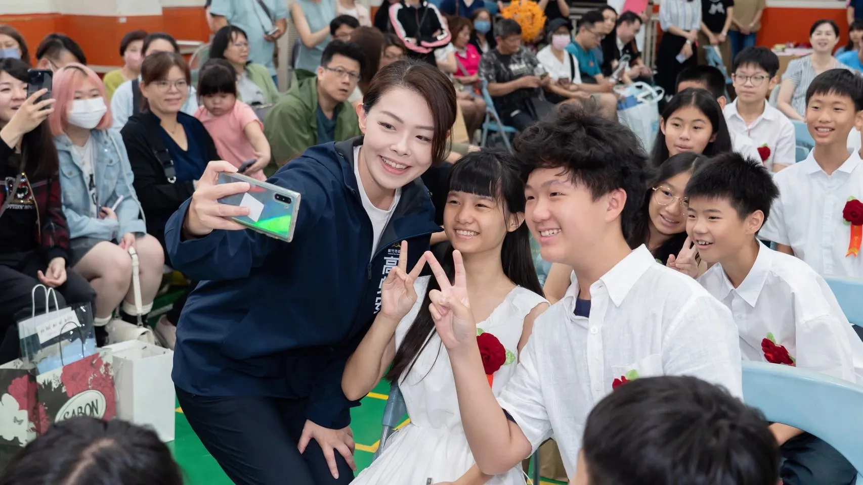 高虹安與學生開心自拍，學生笑著比出勝利手勢，留下校園活動的溫馨合影。（圖/翻拍竹市官網）