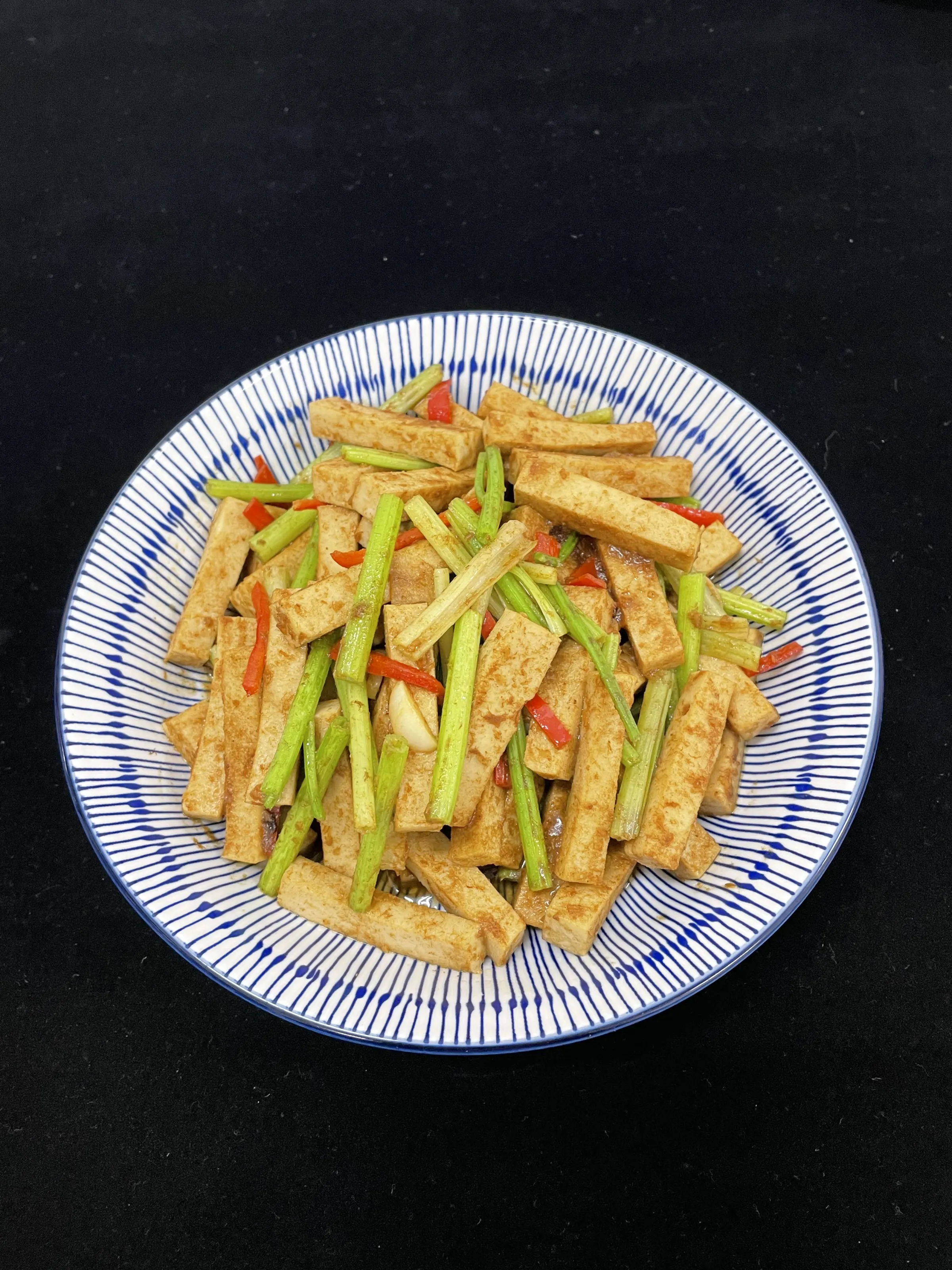 含纖鹹蛋白經質地調整後可切成條狀，搭配芹菜等食材熱炒，讓原本應用受限的鹹蛋加工副產物轉化為可直接入菜的食品素材。（圖／畜試所提供）