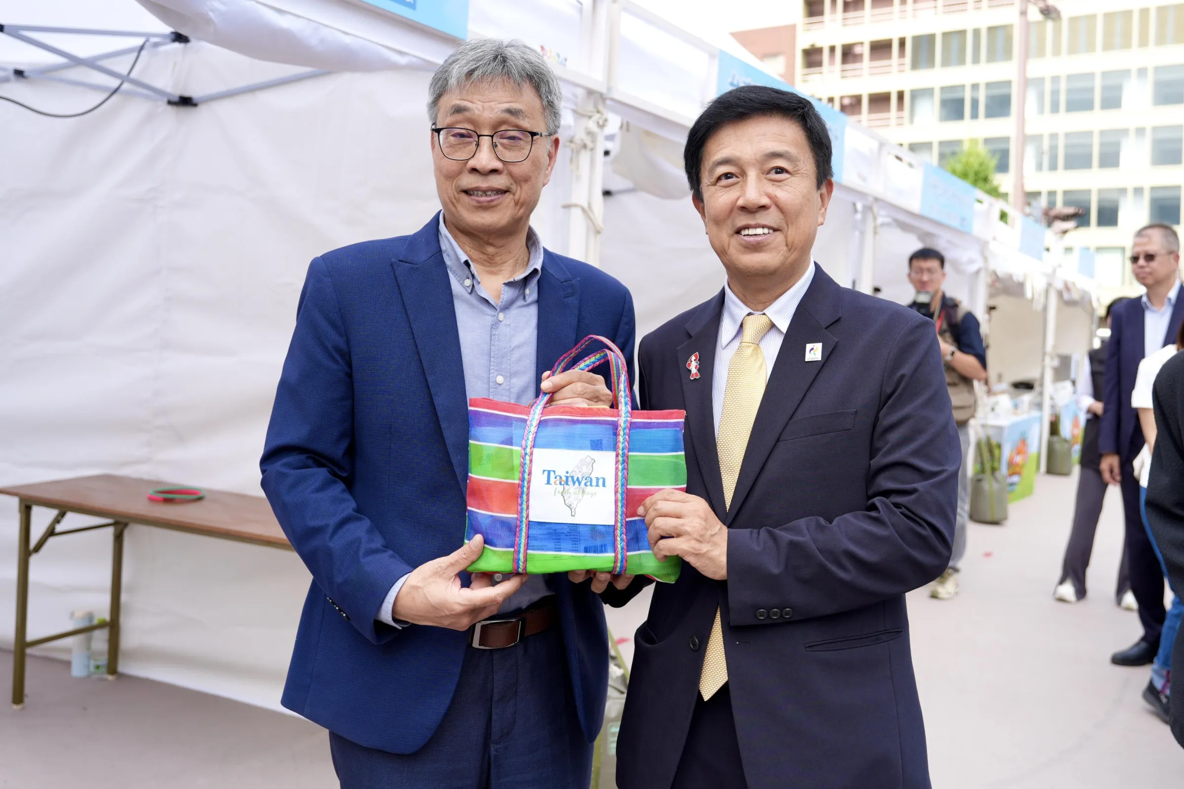 農業部長陳駿季（左）於名古屋「農力應援」活動與日方貴賓交流並致贈台灣特色紀念品，藉亞運契機深化台日農業及市場交流。(圖/農業部提供)