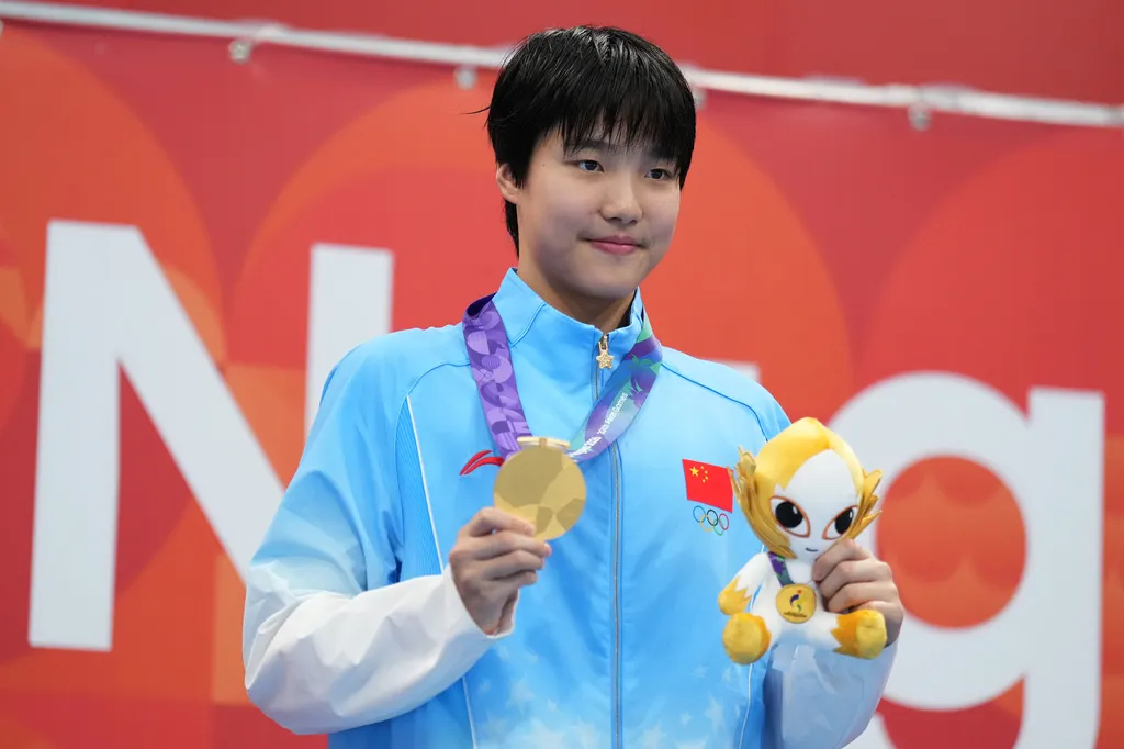 Yu Zidi celebrates after winning the women's 400-meter individual medley at the Aichi-Nagoya Asian Games, her third gold of the Games.
