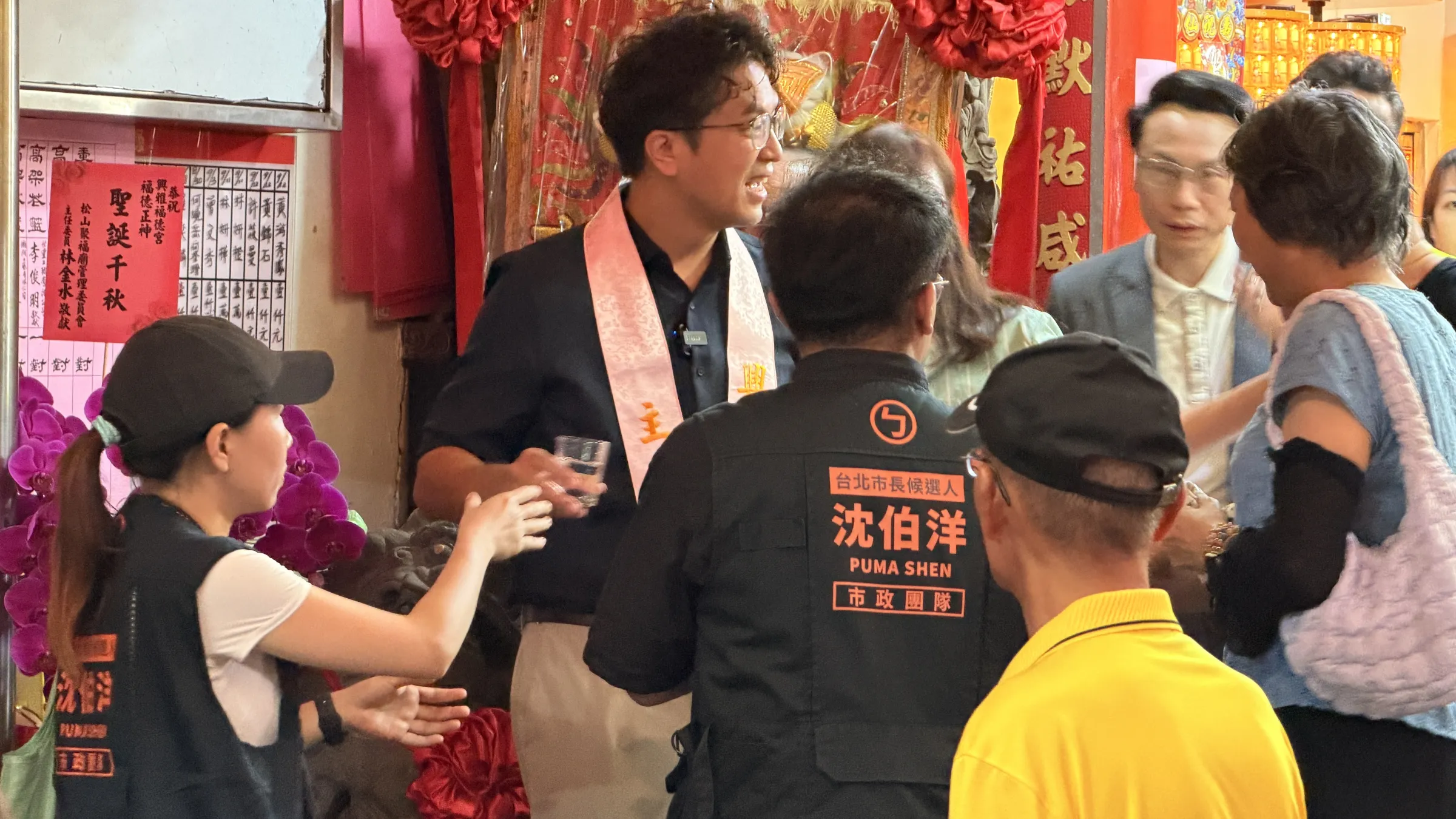 沈伯洋氏（左から2人目）の陣営はすでに50人を超えるが、黒地にオレンジ文字のベストを着た人たちが沈氏の側近・中核スタッフだ（鍾秉哲撮影）