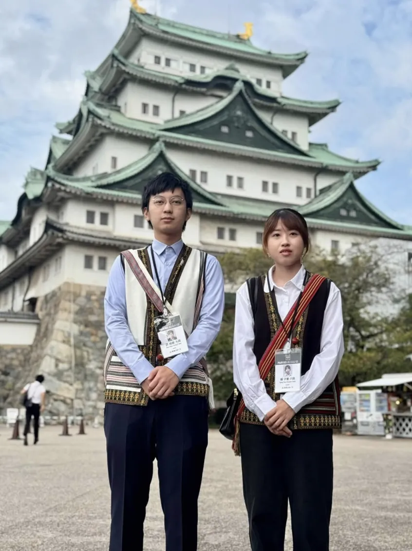 許皓鋐九段、楊子萱六段身著原住民風格服飾，於名古屋城前留影。（海峰棋院）