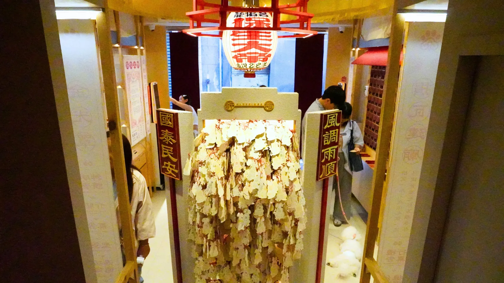 本殿の祭壇の裏にある祈願カードの台。猫や犬の形のカードが掛けられている。両脇の対聯は、国の平安と順調な雨（国泰民安・風調雨順）を願う