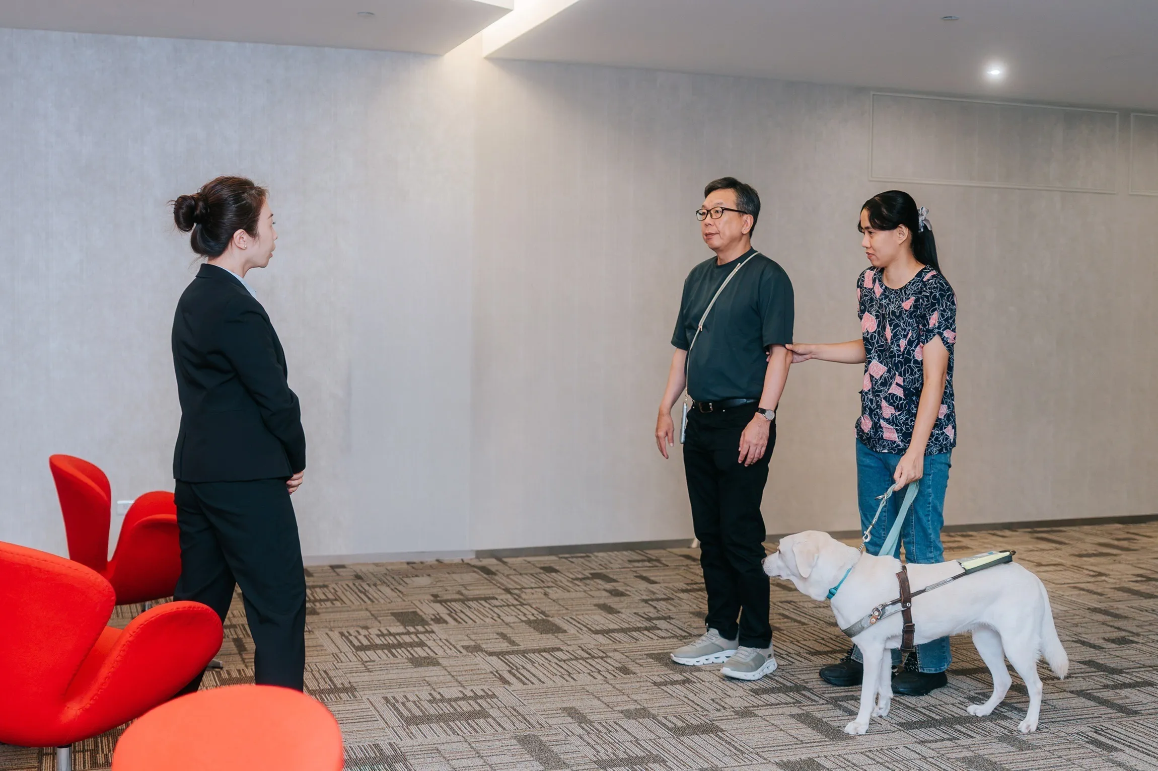 中信銀行獨立董事楊聲勇（中）陪同視障體驗員（右一）檢視無障礙服務流程，肯定分行同仁主動提供具點字標示的存摺套及導讀簽名板。(圖/中信銀行提供)