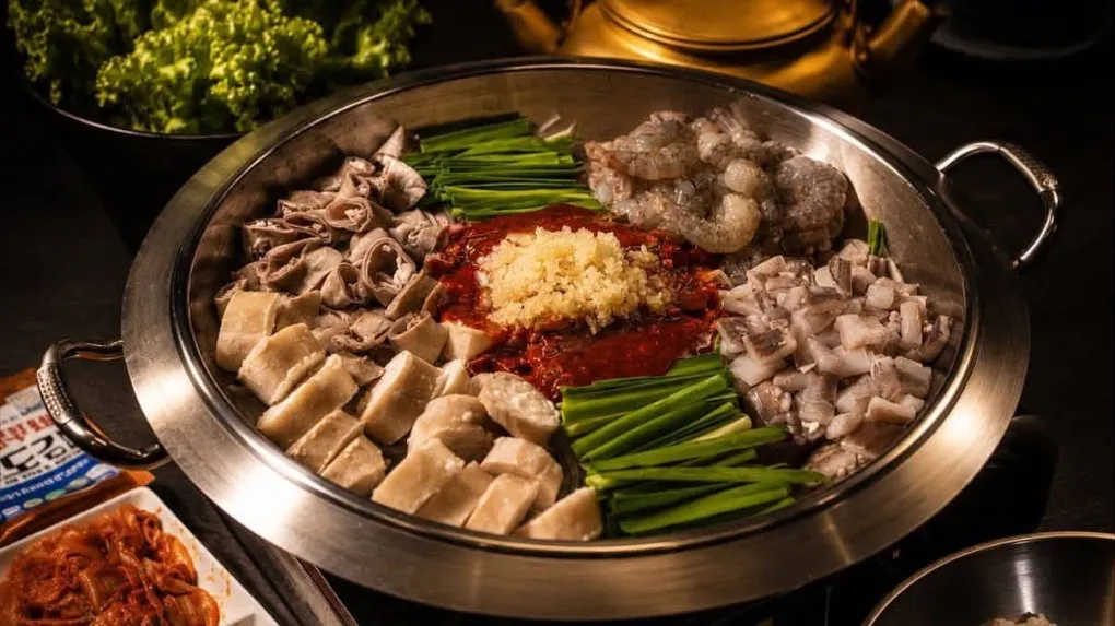 店內必點的「章腸蝦鍋」集合Q彈魷魚、鮮甜蝦子與帶有豐富脂香的腸類，三種不同食材在特製韓式辣醬與高湯中慢慢熬煮，海鮮鮮味與脂香融合進湯底，呈現濃郁香辣的風味。（圖/徐炳文翻攝）