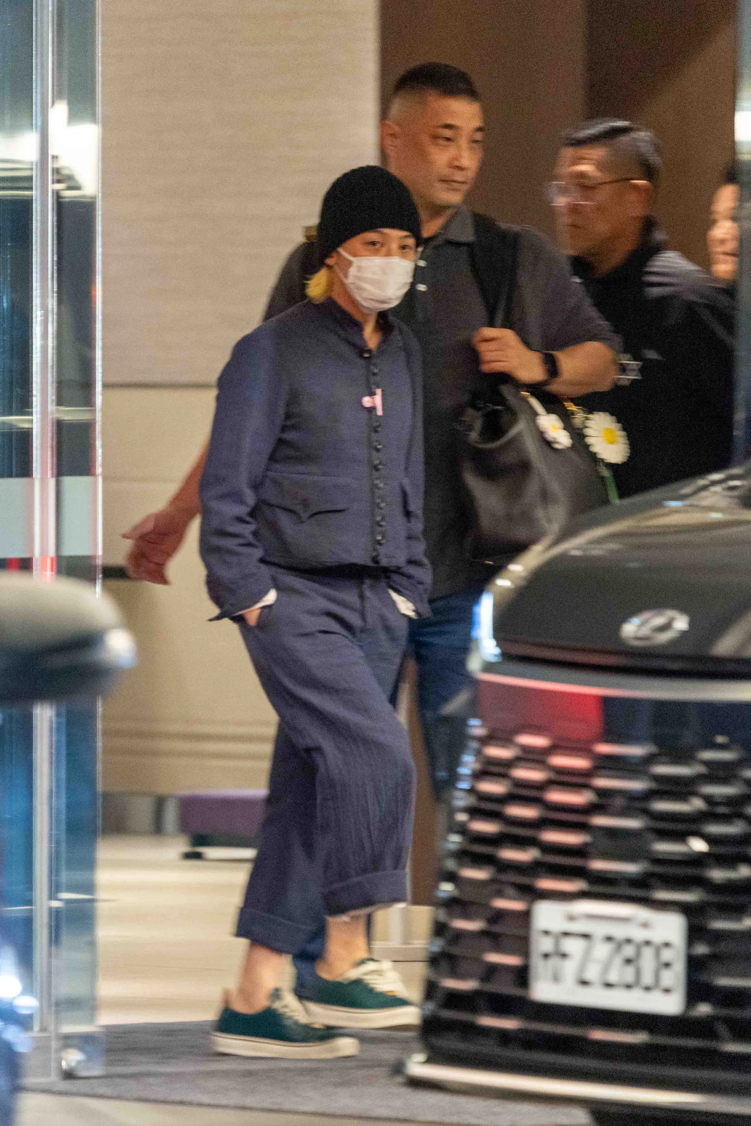GD頭戴毛帽走出松山機場商務中心，沒有停下腳步，隨即搭上等候車輛離開。（圖／張一笙攝）