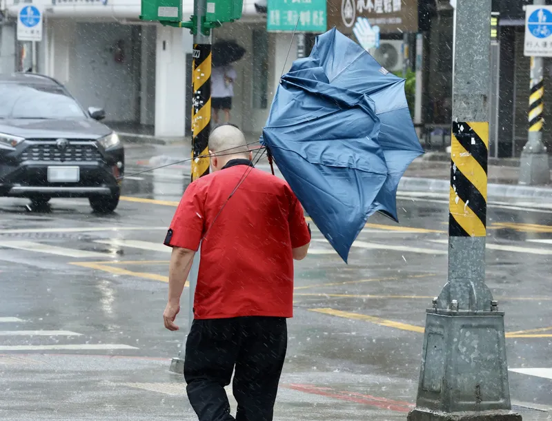 薔琵颱風暴風圈籠罩台灣本島，新北市23日出現強陣風，外出民眾雨傘被吹壞。（圖／中央社記者張皓安攝）