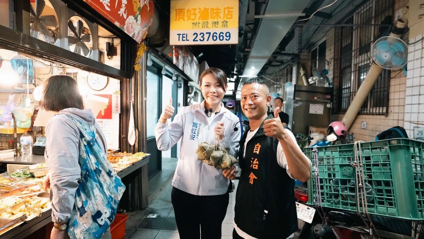 高虹安左提著象徵「包中」的粽子，與市場人士一同比讚合影，爭取基層支持。（圖／高虹安競辦提供）