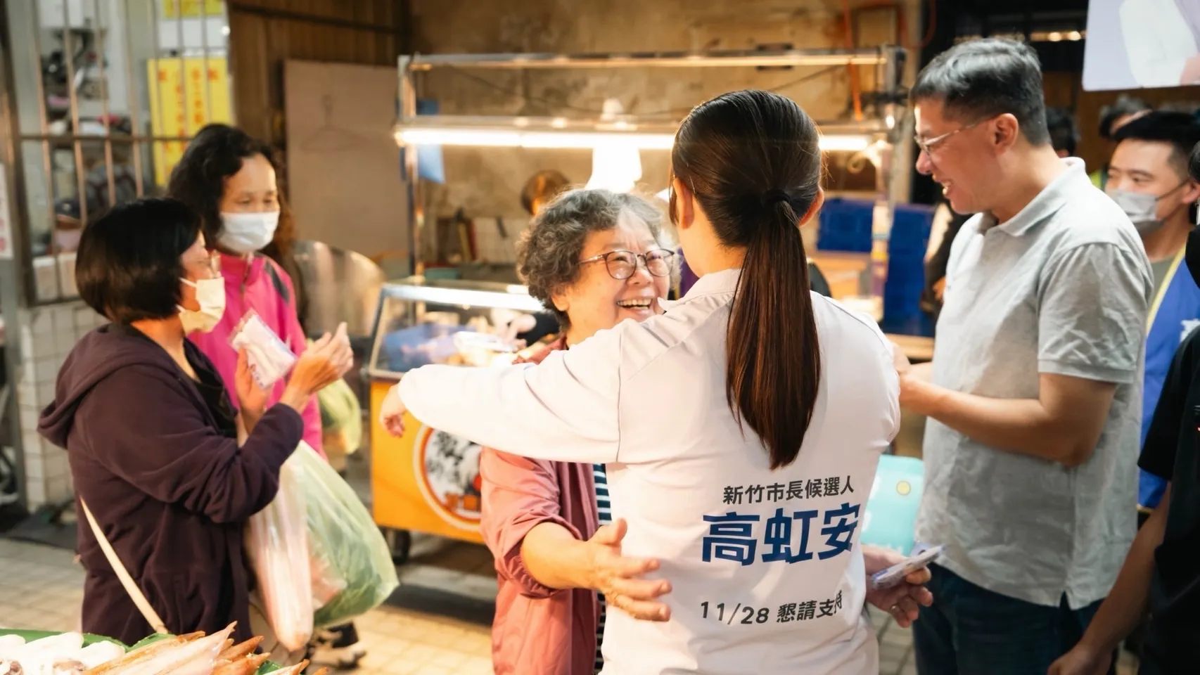 高虹安在市場拜票時與女性民眾擁抱，周邊民眾在旁互動，現場氣氛熱絡。（圖／高虹安競辦提供）