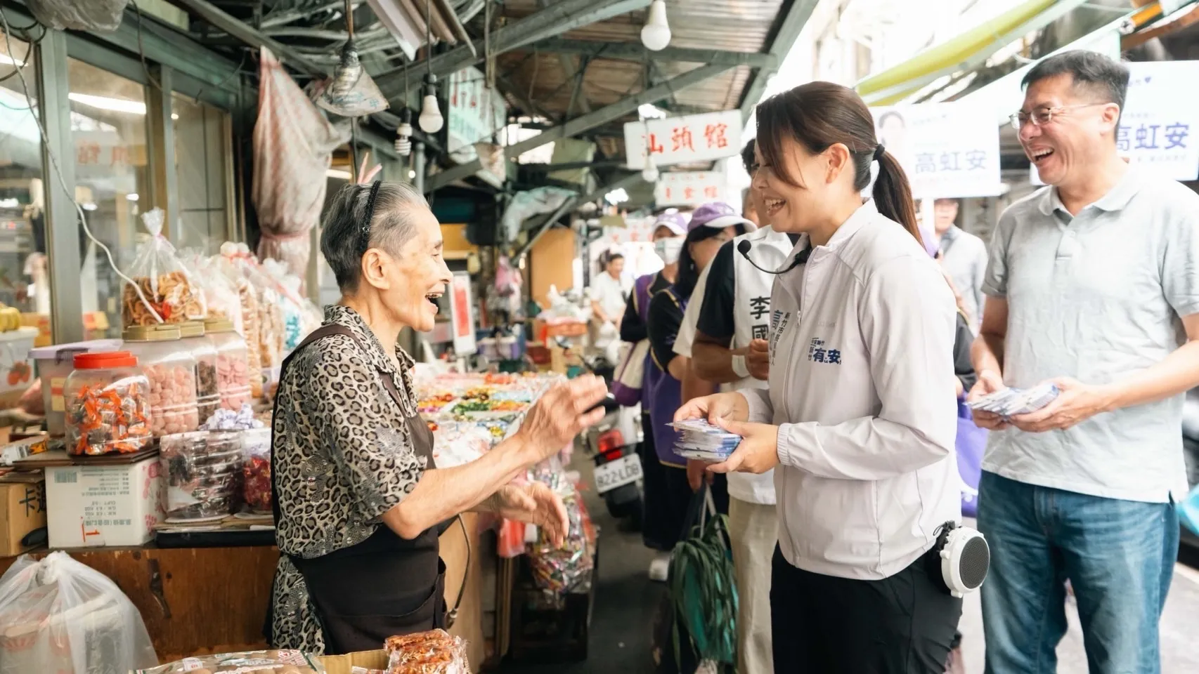 高虹安右手持競選文宣面紙，停下腳步與女性攤商交談，聽取民眾聲音。（圖／高虹安競辦提供）