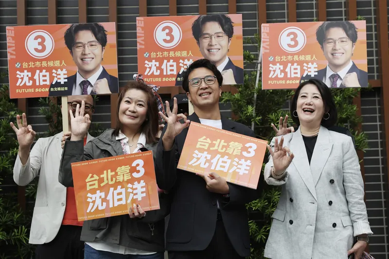 2026年10月27日，民進黨台北市長參選人沈伯洋（中）出席台北市選舉委員會舉行的候選人號次抽籤活動，由市民主委Lydia Lin（左）代表抽中3號，沈伯洋在抽籤後與競選總幹事吳思瑤（右）等人開心比出3號手勢。（中央社）