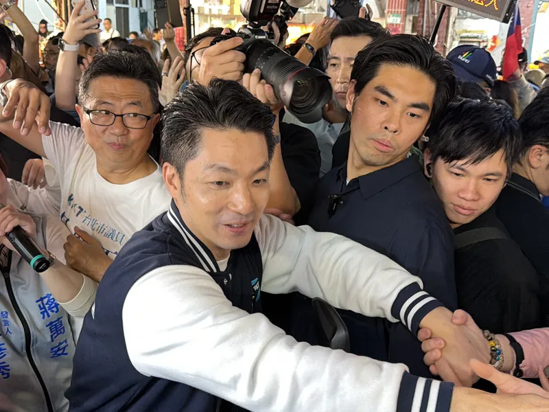 2026年10月27日晚間，台北市長蔣萬安（前左）赴內湖737夜市掃街拜票，現場支持者眾多，蔣萬安也熱情握手互動。（中央社）