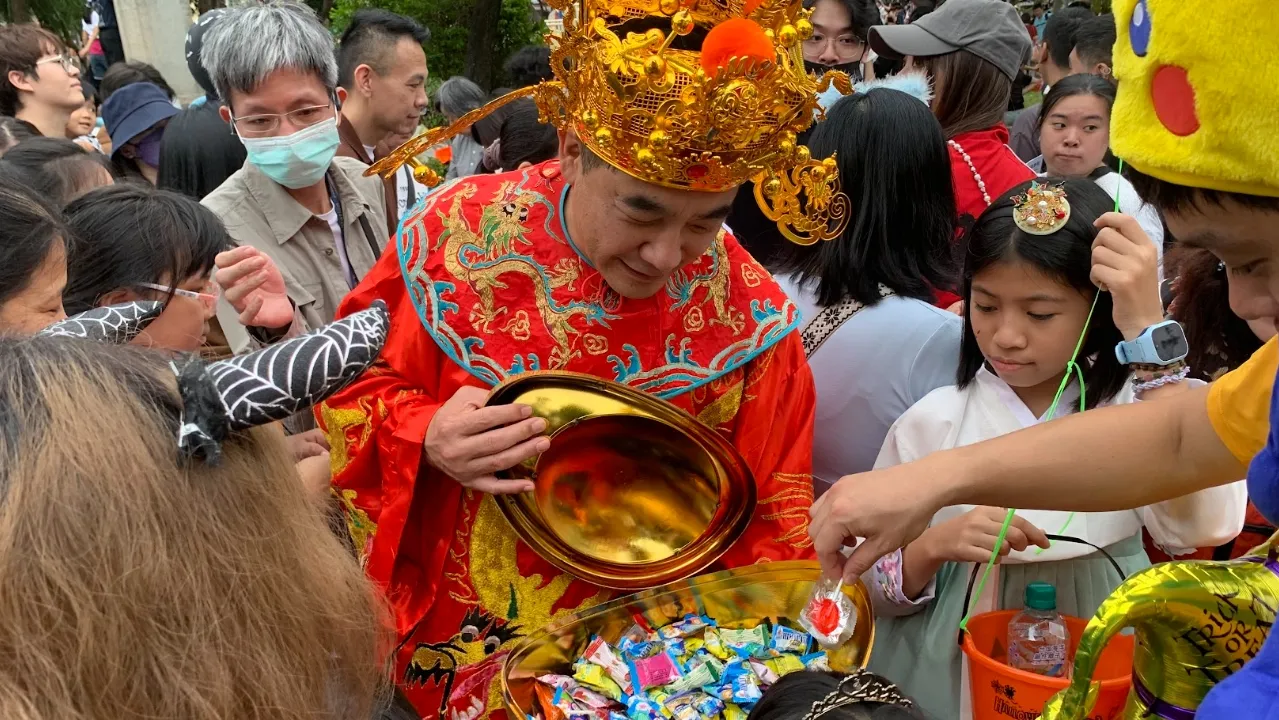 財神造型參與者手捧裝滿糖果的金色元寶，與孩子互動同樂。（圖/泰北國際雙語學校提供）