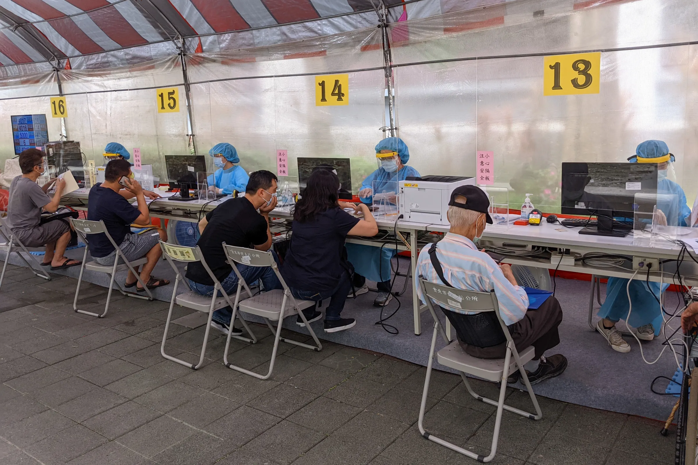 20210616-因應新冠肺炎疫情三級警戒，財政部北區國稅局將報稅業務移至戶外，稅務人員也著全套防護衣為民眾服務。（顏麟宇攝）