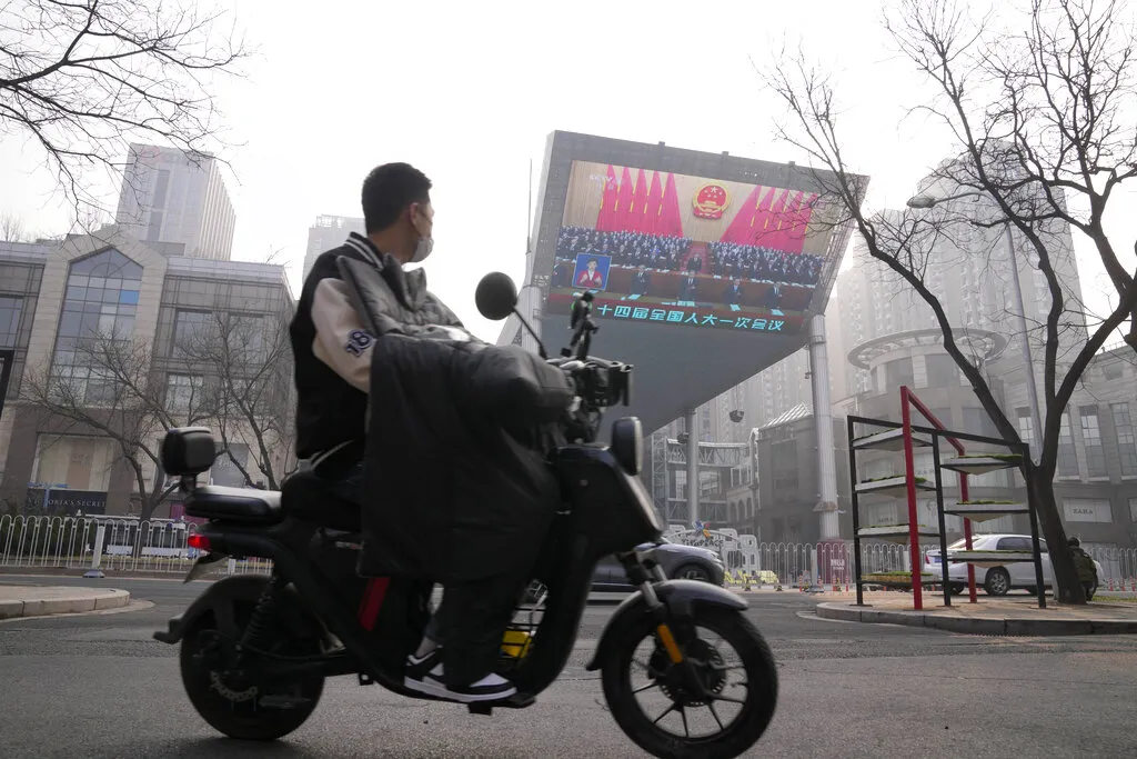 2023年3月,中國兩會期間北京街頭正在播放相關新聞。(美聯社)