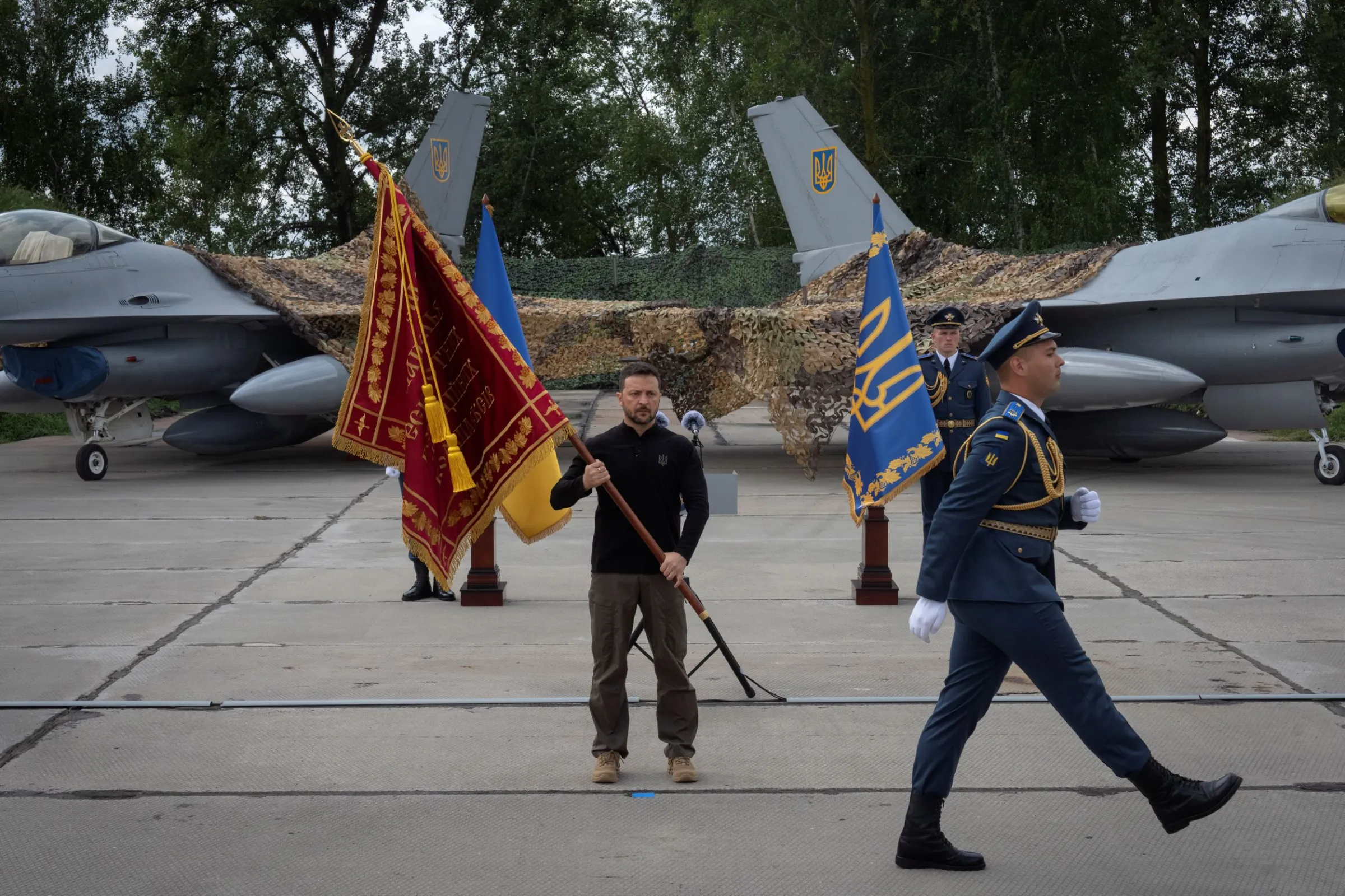 手持軍團旗幟與美援F-16戰機合影的澤倫斯基。(美聯社)