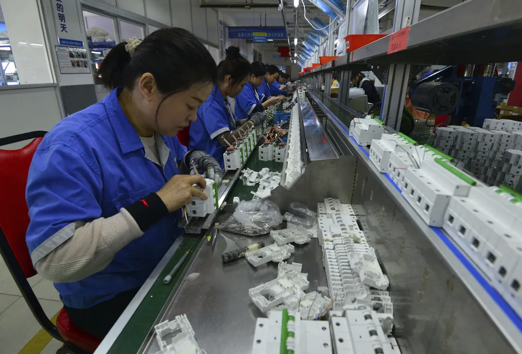 2025年4月15日。工人在中國中部安徽省阜陽市的一家電子裝置工廠組裝斷路器。(AP)