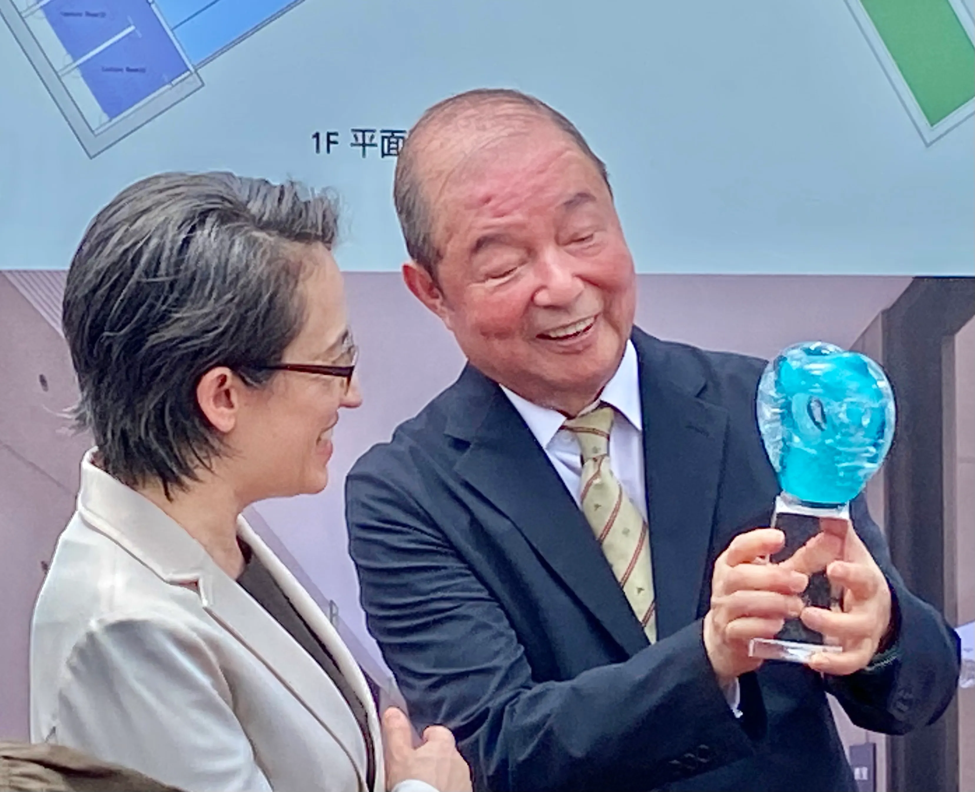 20250909-玉山金控創辦人黃永仁(右)9日致贈玻璃造型藝術家田中英樹的作品「清心」給副總統蕭美琴(左),象徵社會由一顆顆的心串聯起來。(陳怡慈攝)