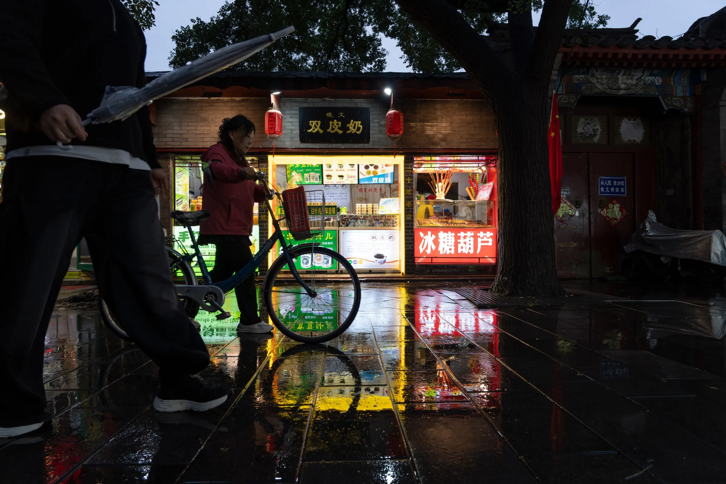 2025年10月9日,雨後的北京南鑼鼓巷,遊客穿行於這條熱門觀光街區。(美聯社)