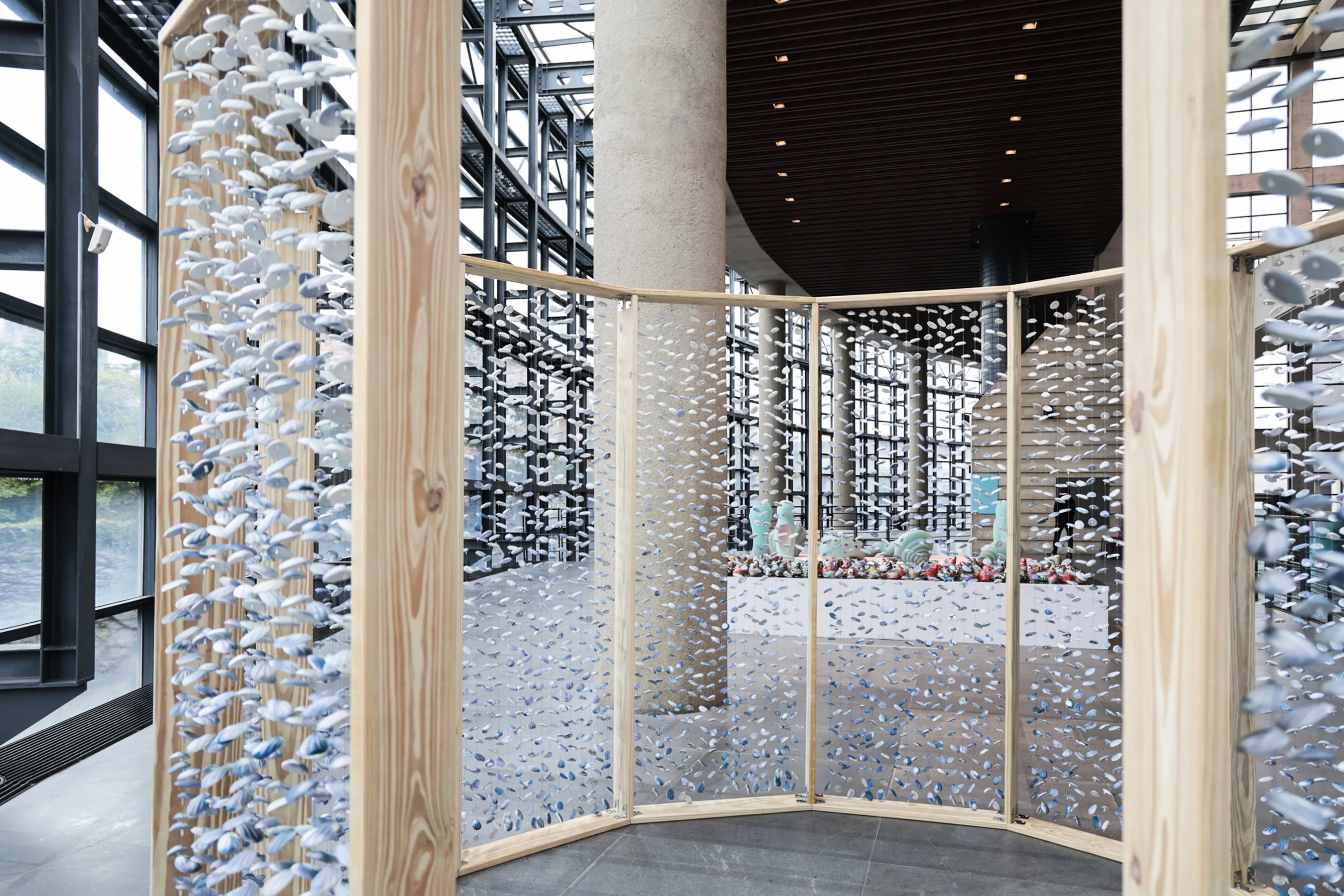 「系列三」數千片藍白陶片如貝殼懸掛的裝置,觀眾可步入其間體驗被陶片環繞的庇護與歸屬感。(圖/新北市立鶯歌陶瓷博物館)
