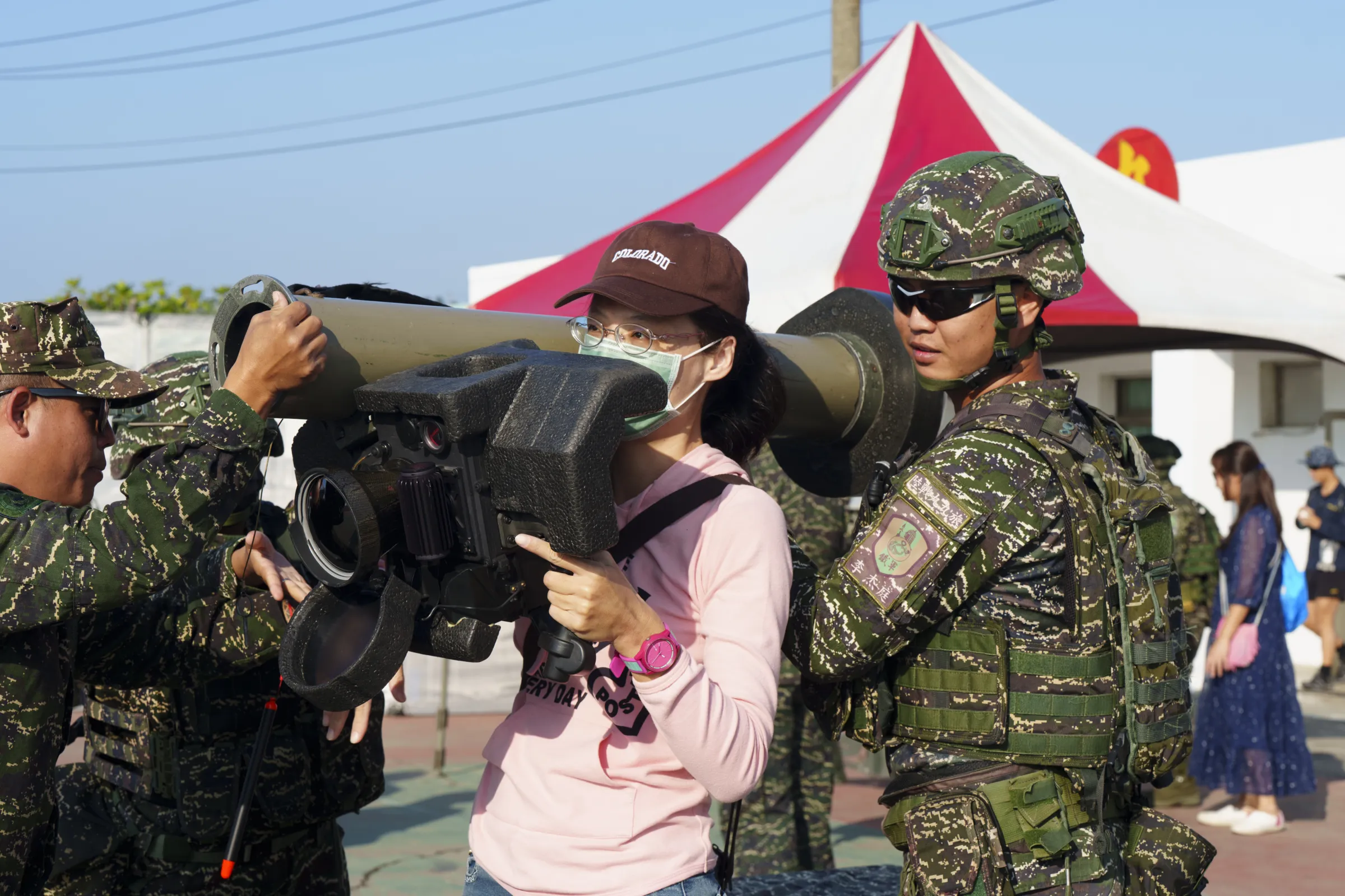 20251122-參觀民眾在官兵協助下,體驗扛起標槍飛彈的感受。(傅啟禎攝)