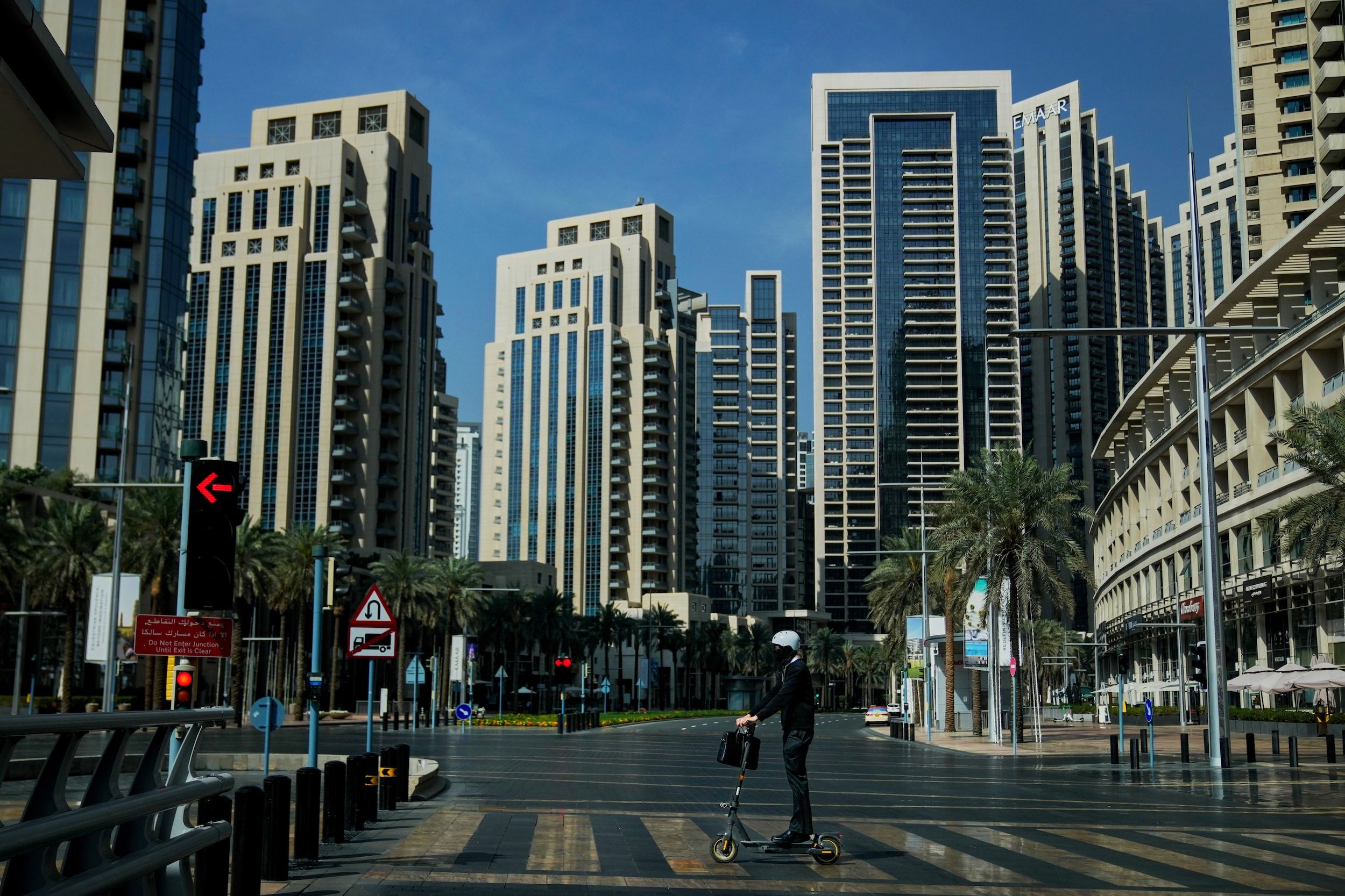 2026年3月1日,一名男子騎著電動滑板車行駛在阿聯酋杜拜市中心一條空曠的道路上。(美聯社)