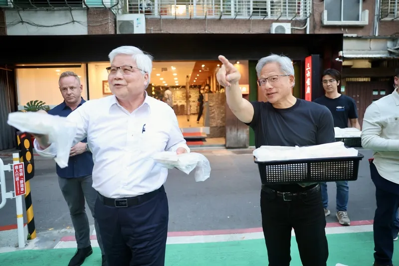 黃仁勳、魏哲家請民眾吃餐點(1) 輝達執行長黃仁勳(前右)與台積電董事長魏哲家(前左)26日在台北市大安區餐敘,中途還不忘關心店外守候群眾,一起拿著餐點到店外分發。中央社記者王飛華攝115年5月26日