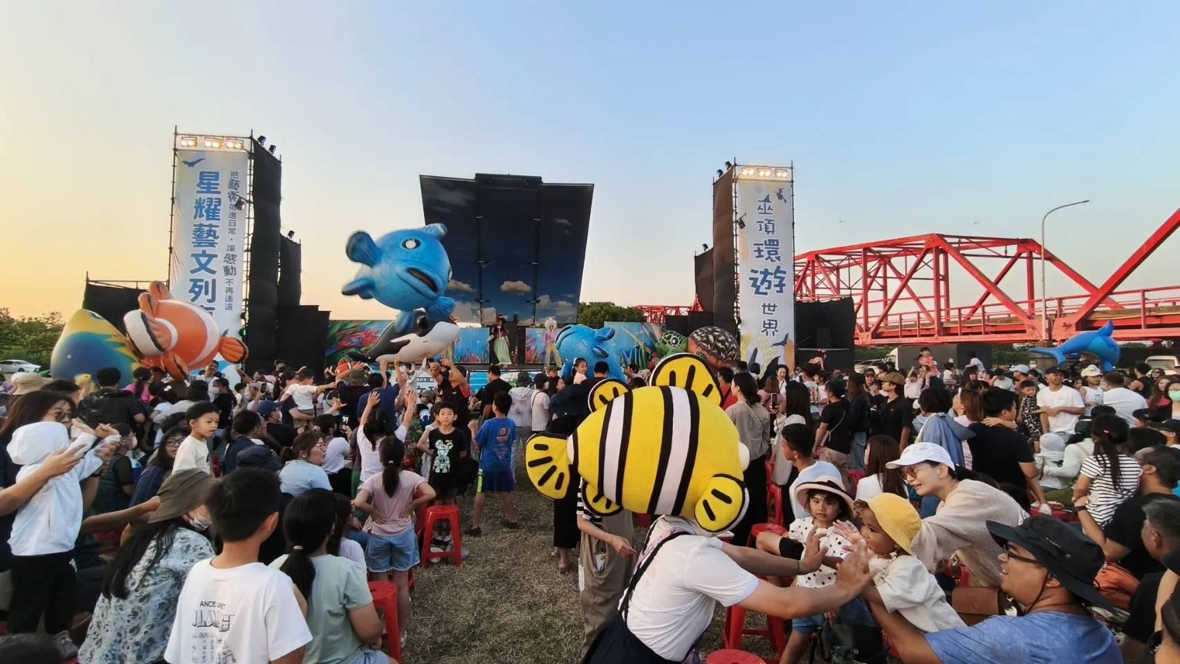 紙風車劇團帶來活潑生動的演出,現場人潮匯聚,在西螺大橋紅色鋼構橋景映襯下,氣氛熱絡溫馨。