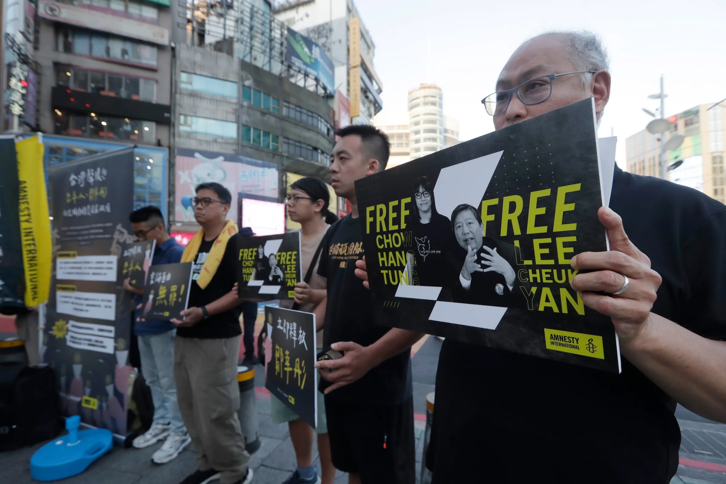 2026年5月31日,香港活動人士和台北的支持者舉著標語,聲援被監禁的香港政治人物和社會活動家。(美聯社)