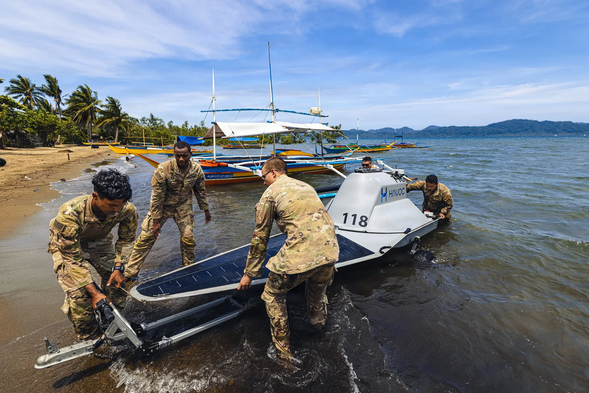 美國陸軍第25步兵師的情報單位官兵,6月初在兩國陸軍演習現場,搬移無人船Rampage。(美國國防部網站)