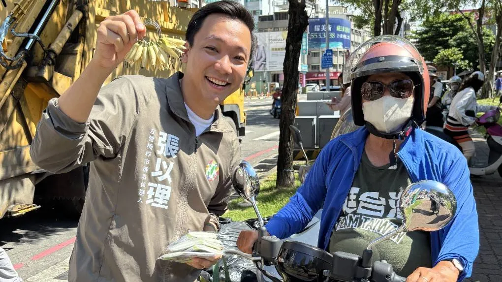 撕掉政務官包袱,走入左楠最真實的日常!市議員參選人張以理(左)利用垃圾車清運時間站上街頭,親切向倒垃圾的鄉親問候、遞送文宣,展現十足的親和力與傾聽民意的決心。(圖/徐炳文翻攝)