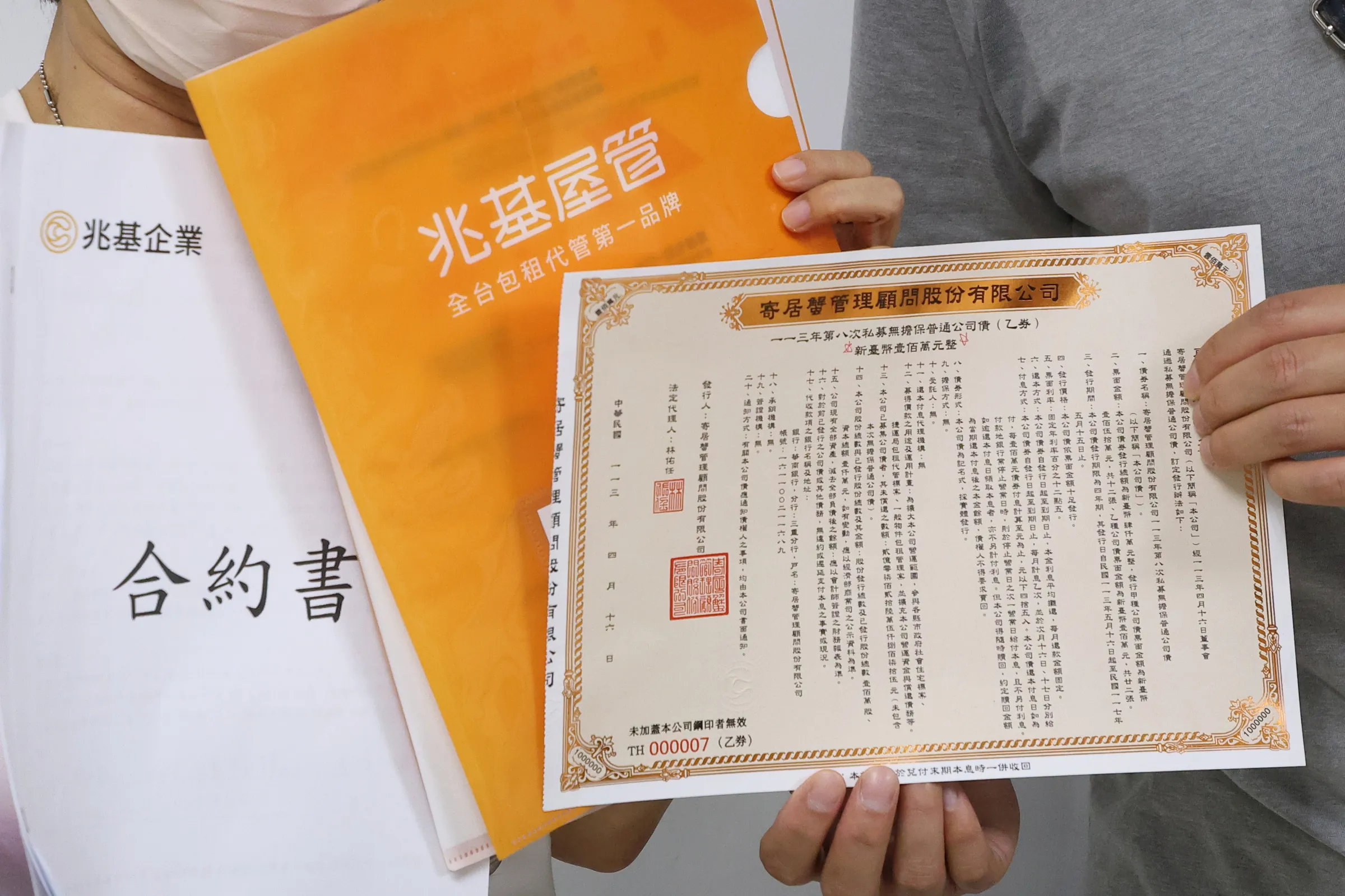 20260812-民眾黨12日舉行「賴政府社宅大跳票,包租代管劣幣驅逐良幣成詐騙溫床」記者會,受害民眾拿出兆基屋管的合約書及寄居蟹公司的公司債。(顏麟宇攝)
